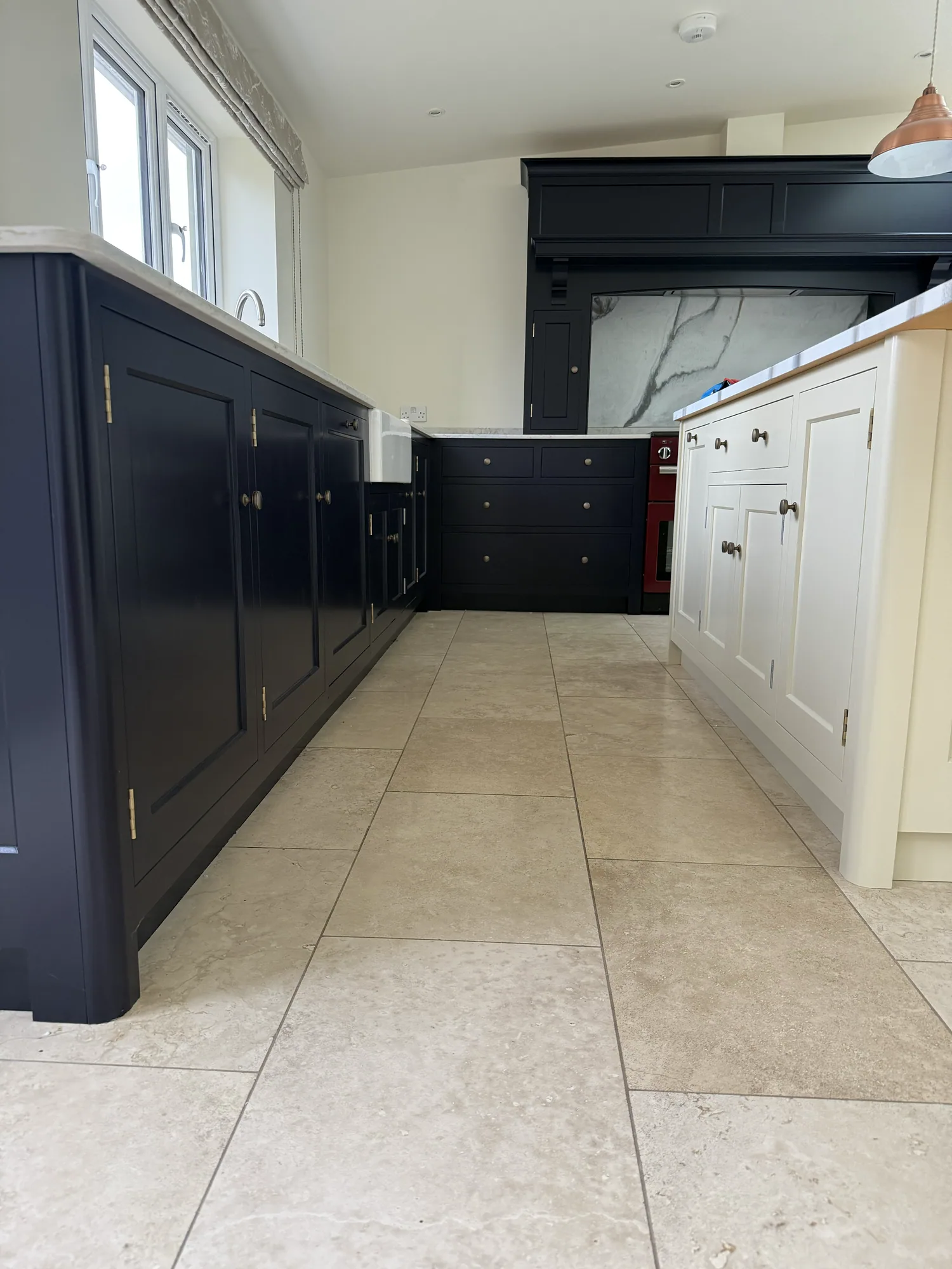 Navy kitchen cabinets resprayed, with copper pendant lighting